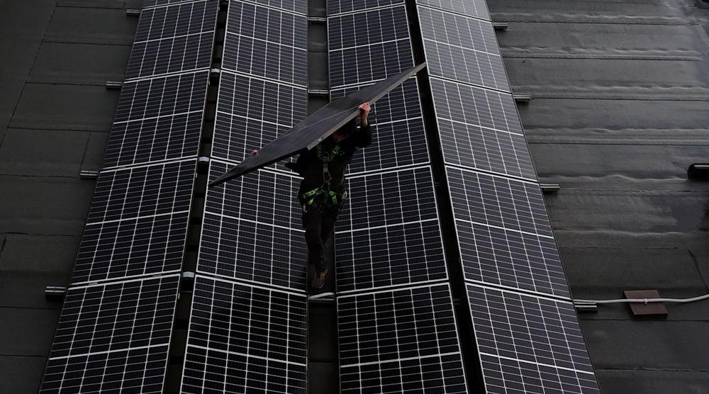 gecertificeerd installateur wandelt over plat dak om zonnepanelen te installeren.